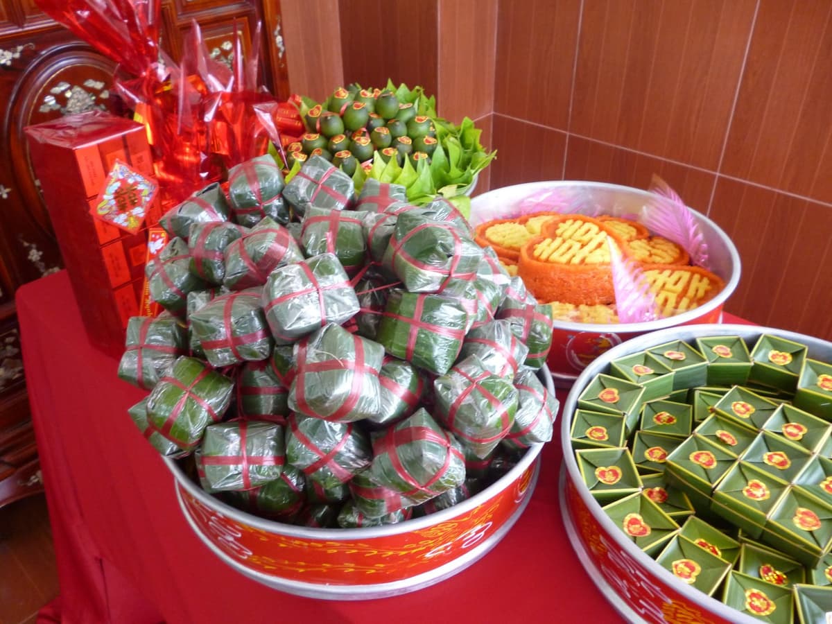 Mâm bánh gói lá buộc dây đỏ, mâm cau và trầu, mâm xôi đỏ, mâm bánh gói lá xanh có dấu chữ Hỷ và hộp quà bọc giấy đỏ.