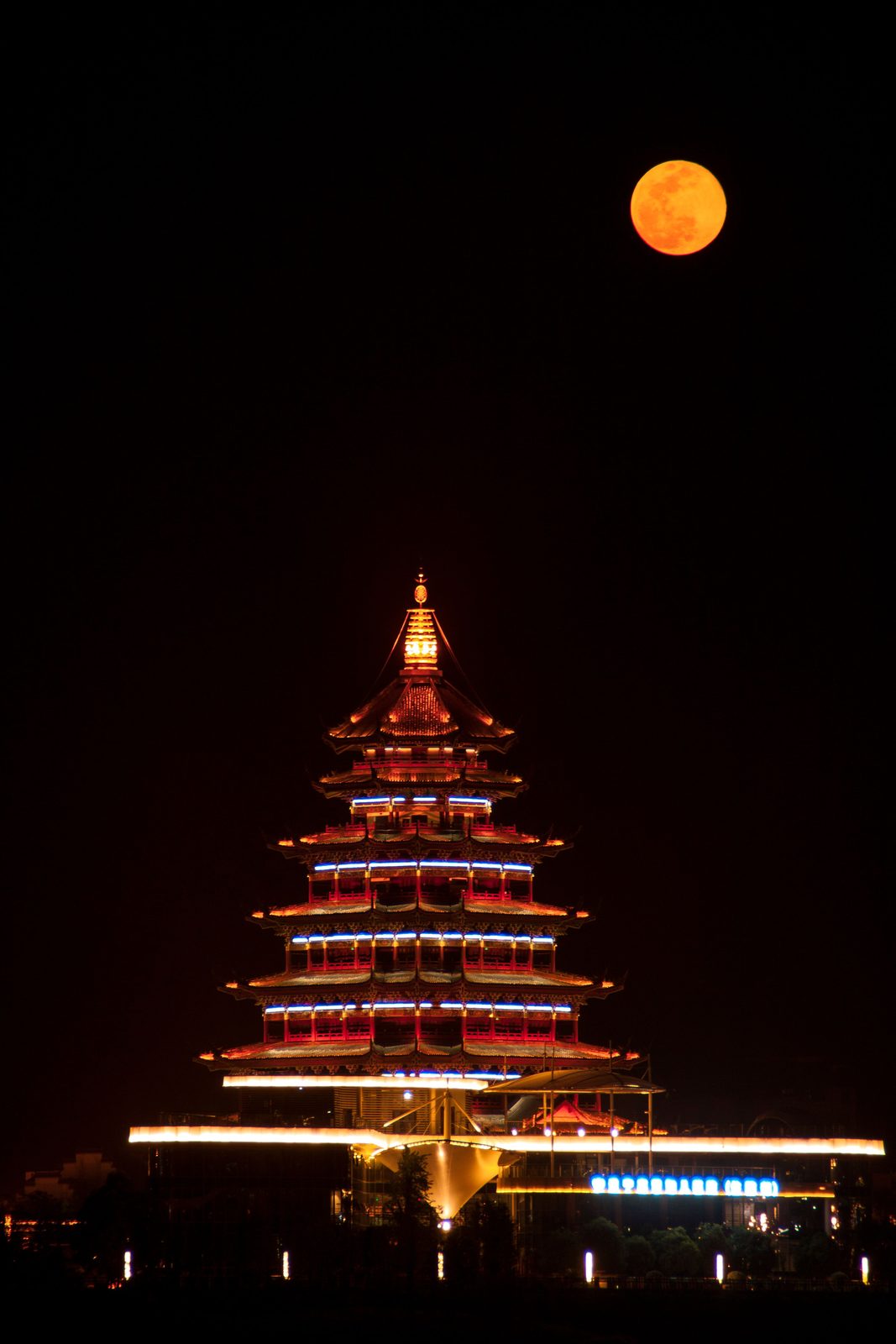 Ngôi chùa sáng đèn giữa đêm, trăng tròn phía trên