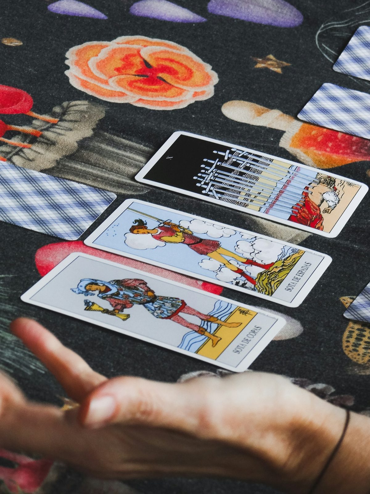 Bài Tarot trải trên bàn, tay đang sắp xếp